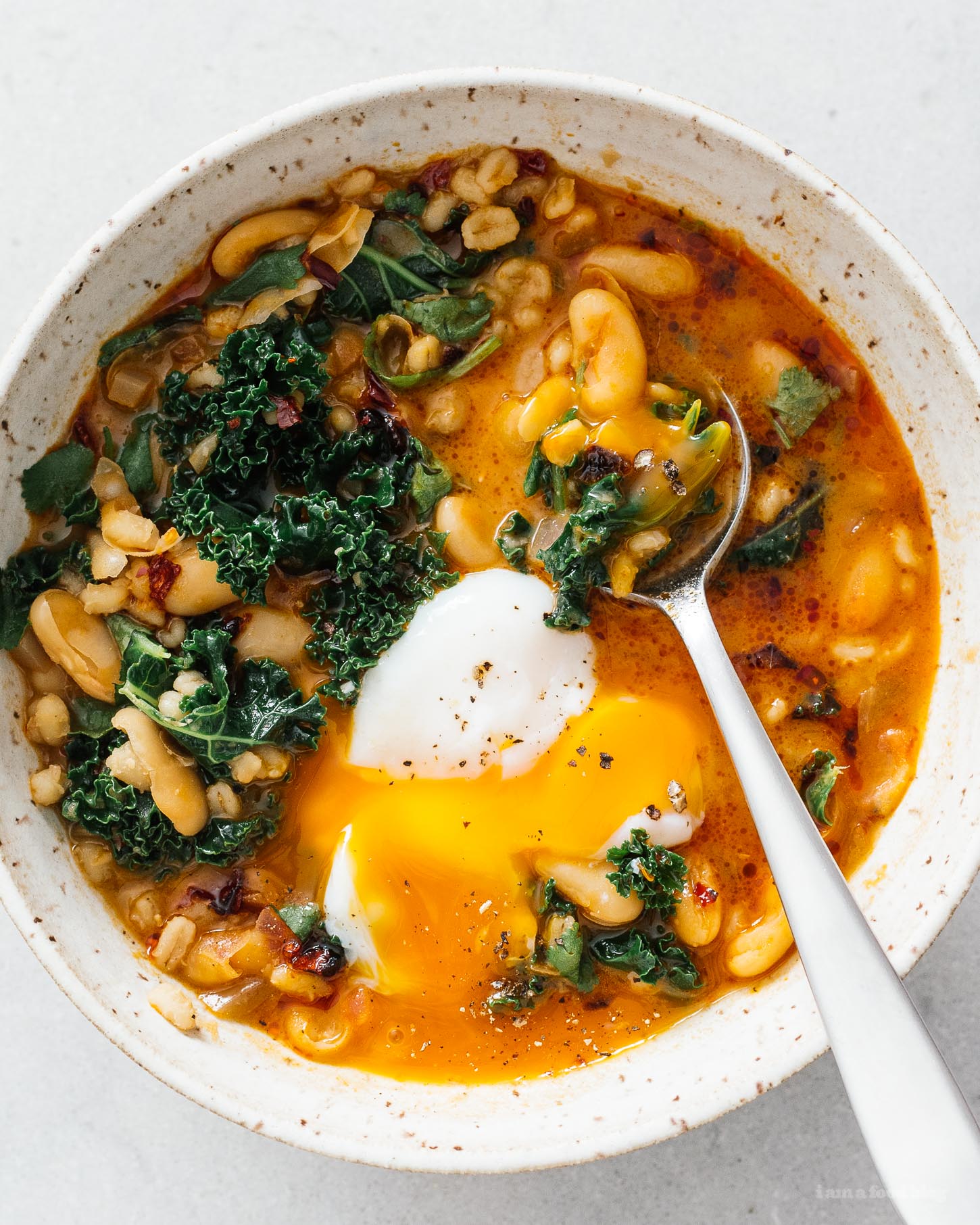 Spicy Chili Crisp White Bean and Barley Stew with Kale and Eggs · i am